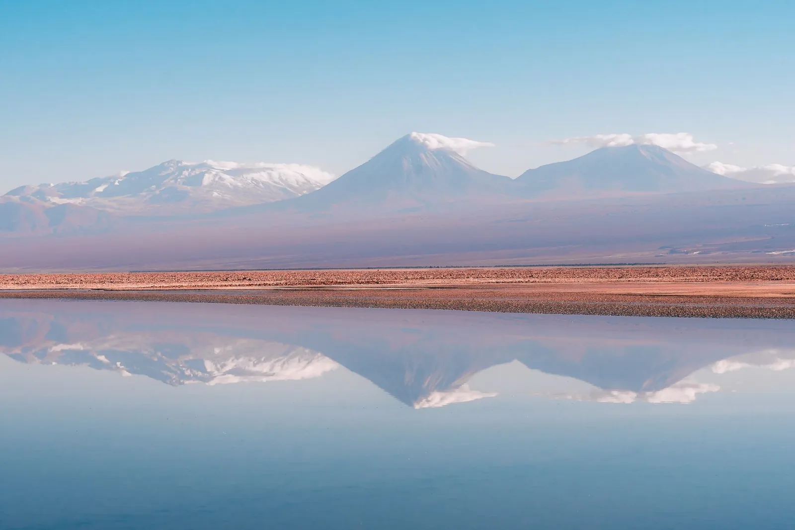 Salar del altiplano chileno reflejando volcanes nevados